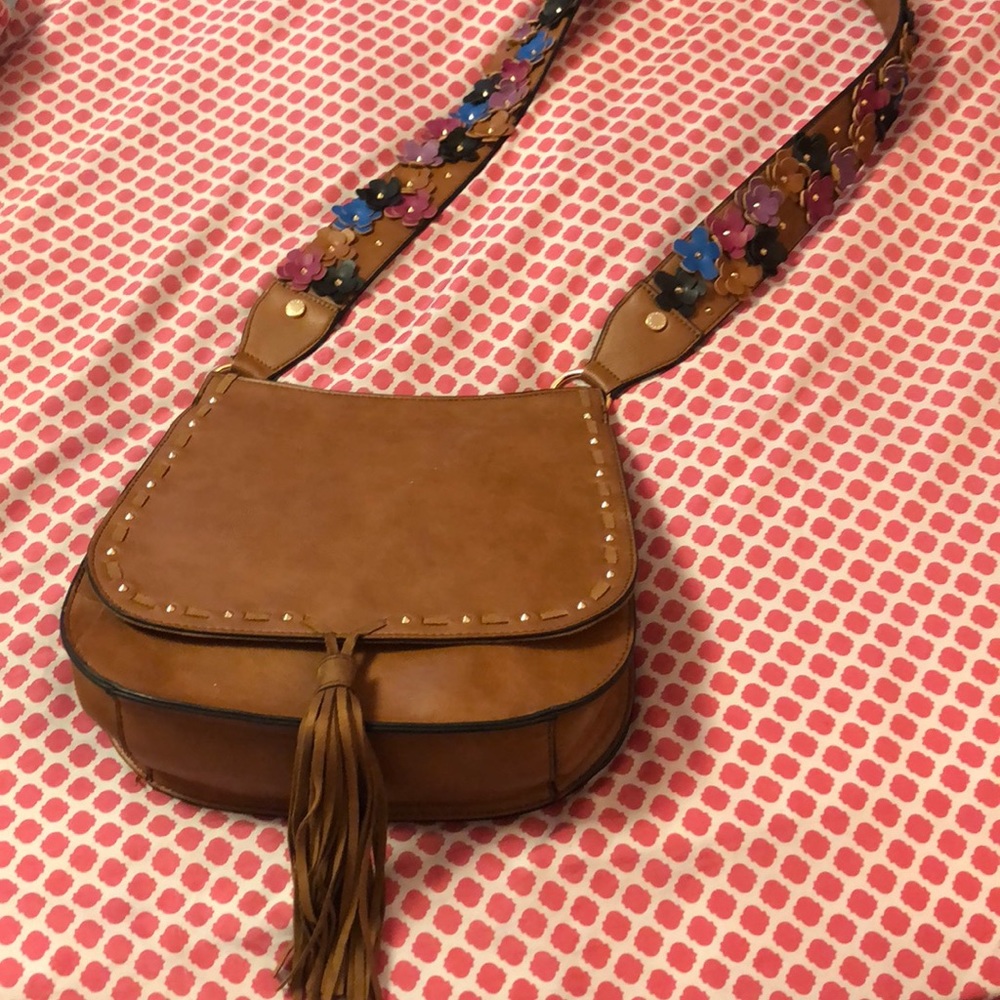 A tan Steve Madden Purse with flowers on handle.